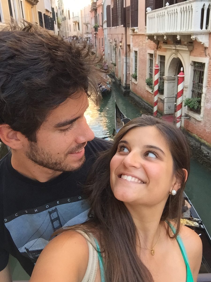 Joana and João on a bridge over a Venetian canal at golden hour.